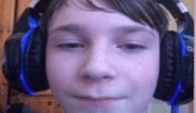 a young boy wearing headphones is making a face .