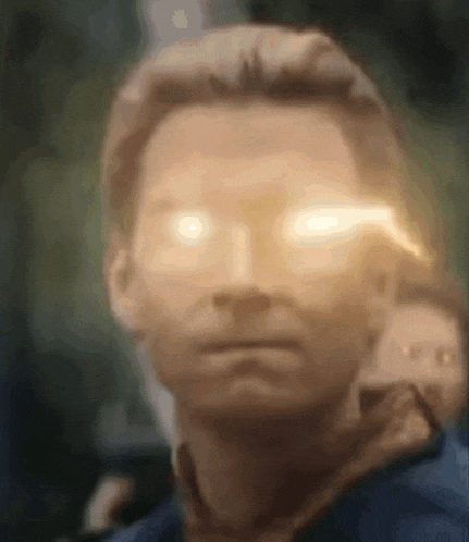 a close up of a man 's face with his eyes glowing brightly .