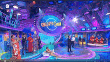 a group of people are standing around a stage with a sign that says galapagos show