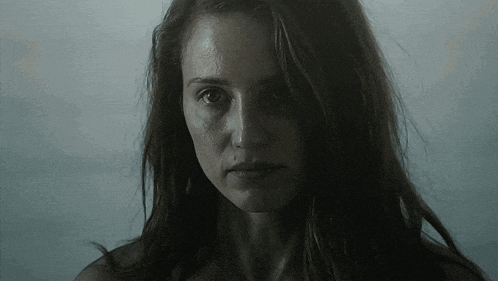a close up of a woman 's face with a serious look on her face
