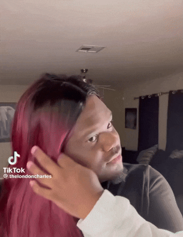 a man with red hair is being touched by a woman 's hand with a tiktok sticker on the bottom
