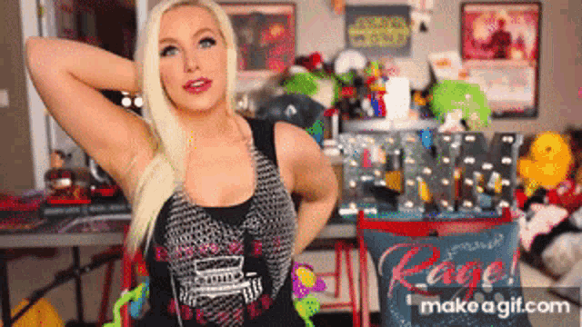 a woman in a black tank top is standing in front of a table with a pillow that says rage on it