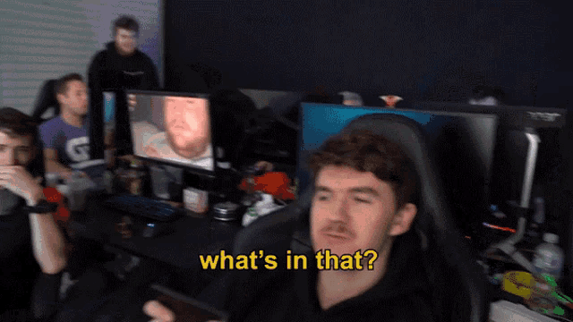 a man sitting in front of a computer with the words " what 's in that " above him