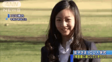 a woman in a suit is smiling in front of a news screen