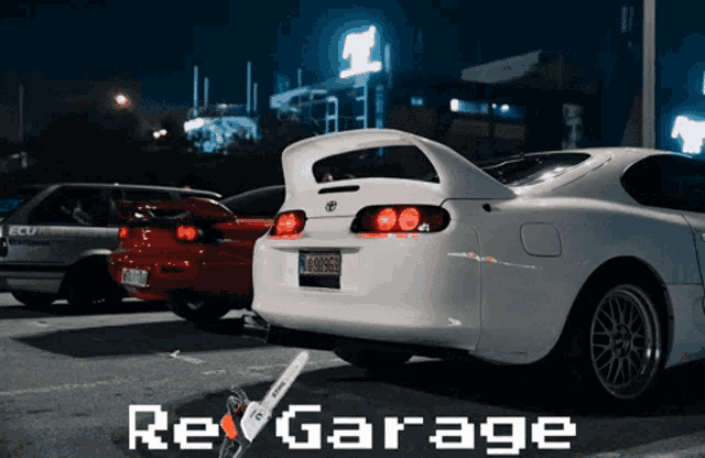 a white toyota supra is parked in a parking lot next to other cars