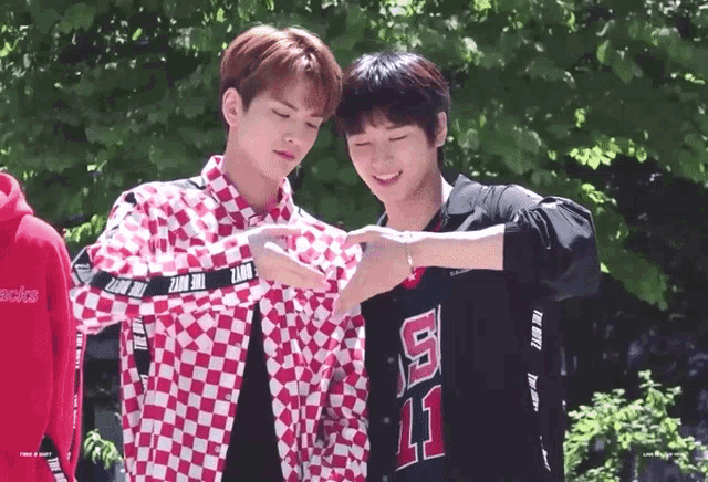 two young men are standing next to each other one wearing a shirt with the number 11 on it