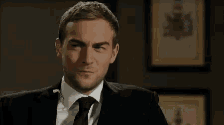 a man in a suit and tie is saying nice .