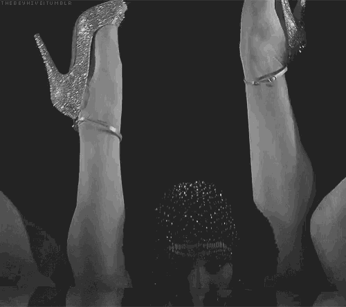 a black and white photo of a woman wearing a headpiece and shoes