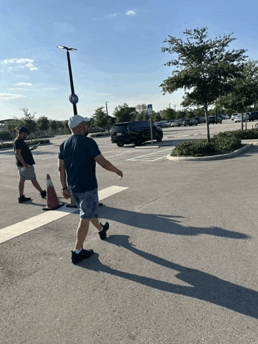 a man walking in a parking lot with a sign that says no parking on it