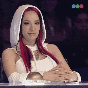 a woman with red hair wearing a white hooded top