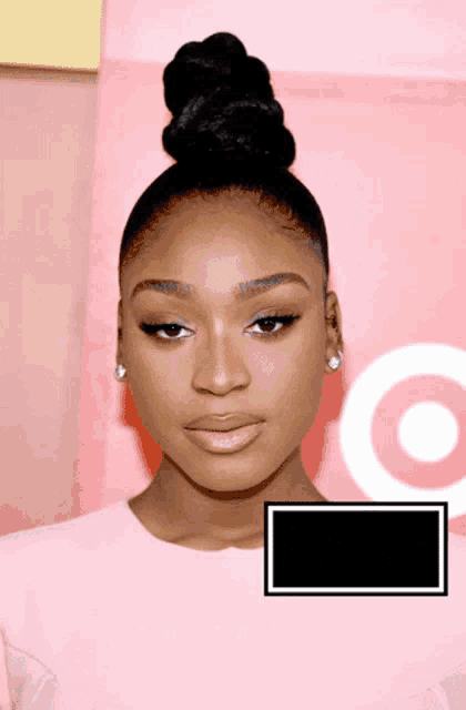 a woman with a bun on her head is standing in front of a target sign