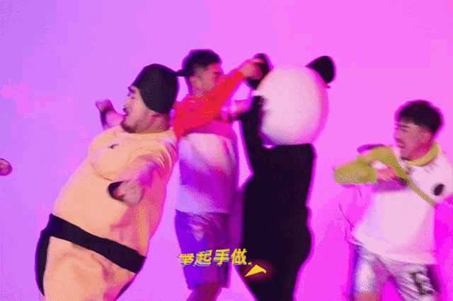 a group of people are dancing in front of a pink background with chinese writing