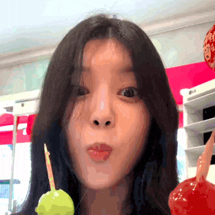 a woman holding a lollipop in front of a lg sign