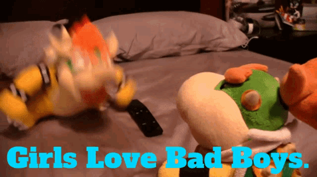 two stuffed animals are on a bed with the words girls love bad boys