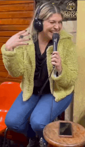a woman wearing headphones is holding a microphone