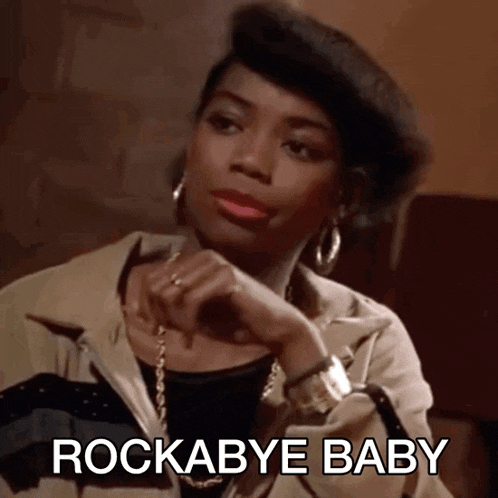 a woman wearing a beret says rockabye baby while sitting down