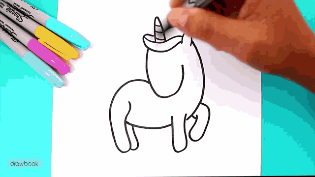 a person is drawing a unicorn on a piece of paper with sharpie markers
