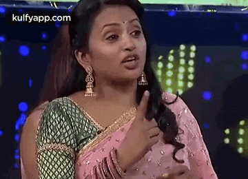 a woman in a pink saree is giving a thumbs up .