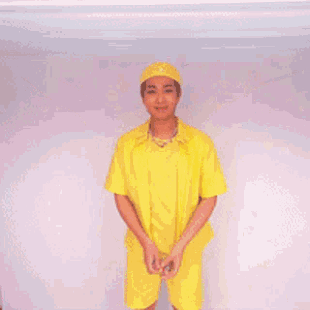 a man in a yellow shirt and shorts is surrounded by confetti falling from the ceiling