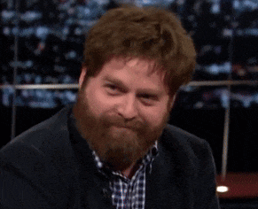 a man with a beard wearing a plaid shirt and a black jacket