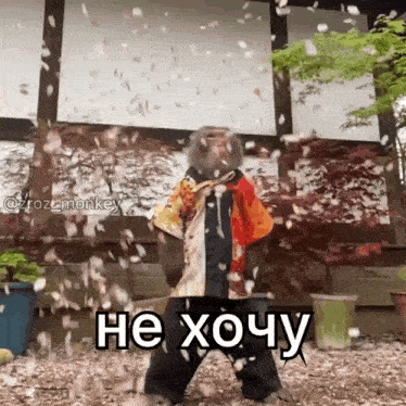 a monkey is standing in front of a building with petals falling around him