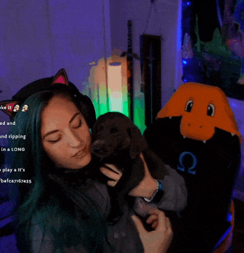 a woman with green hair is holding a dog in front of a stuffed animal that says q