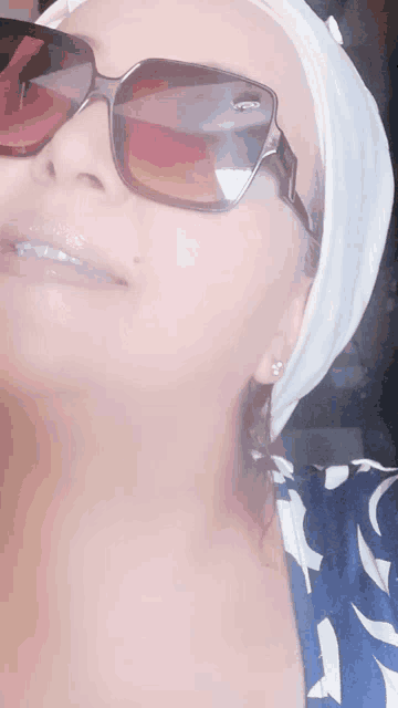 a woman wearing sunglasses and a white turban