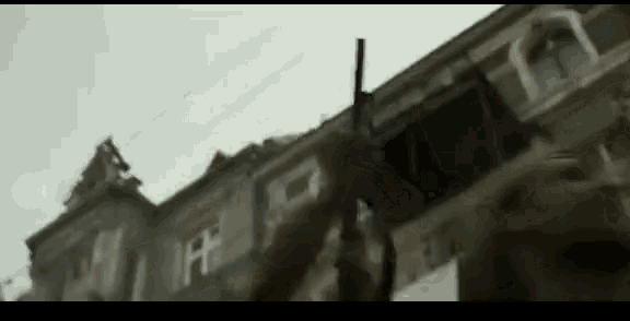 a person is holding a gun in front of a building with a sign that says ff on it .