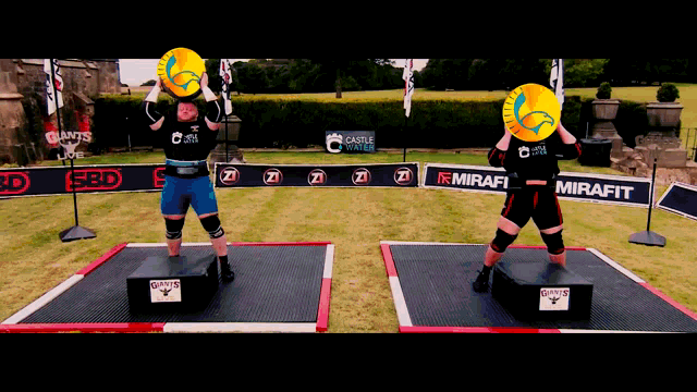 a man is lifting a large yellow object in front of a sign that says mirafit on it
