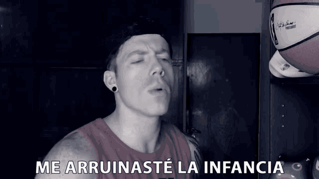 a man wearing a red tank top with the words me arruinaste la infancia on it