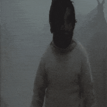 a silhouette of a man standing in a foggy area