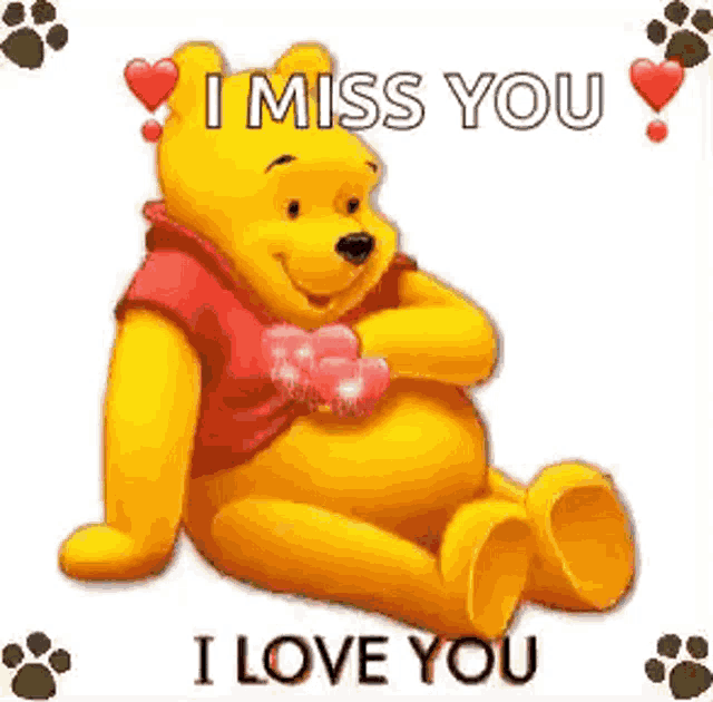winnie the pooh is sitting down with a heart in his hand and says `` i miss you '' .