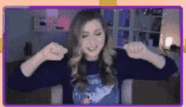 a woman is sitting in front of a computer screen with her arms outstretched and smiling .