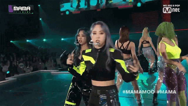 a group of women are dancing on a stage with the words mama on the bottom