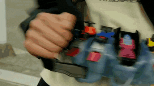 a blurry picture of a person 's hand holding a bottle with a red button on it