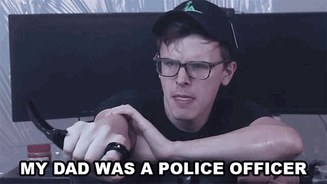 a man with glasses and a hat says " my dad was a police officer " while holding a knife