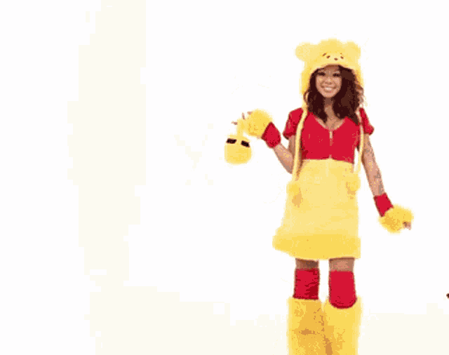a woman in a winnie the pooh costume holds a stuffed animal in her hand