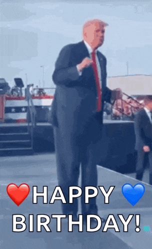 a man in a suit and tie is standing on a stage with the words happy birthday written below him