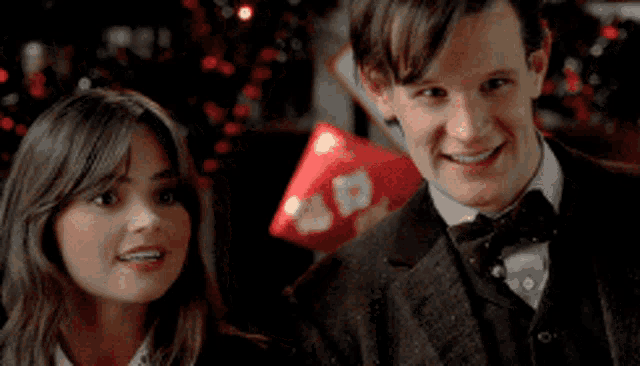 a man and a woman are standing next to each other smiling .