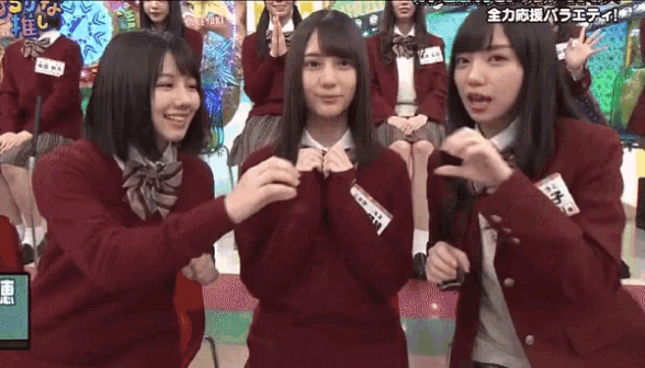 three girls in school uniforms are making funny faces