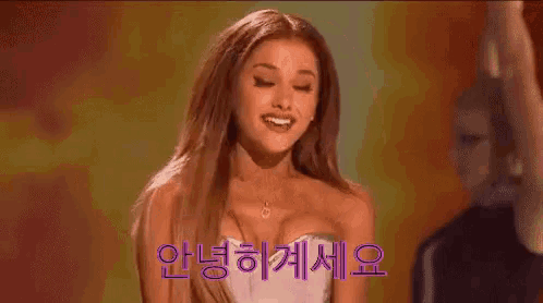 ariana grande is covering her mouth with her hand while standing on stage .