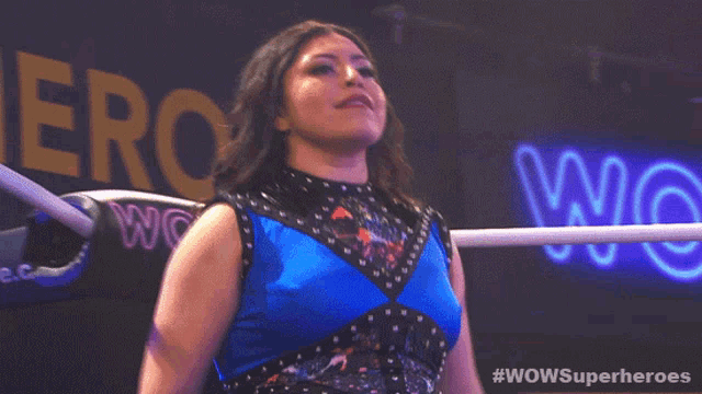 a woman in a wrestling ring with #wowsuperheroes written on the bottom right
