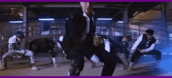 a group of men are dancing together in a dark room