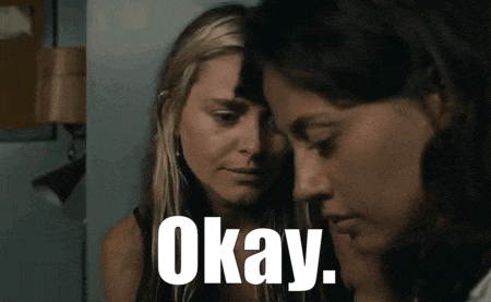 two women are standing next to each other and the word okay is on the screen .