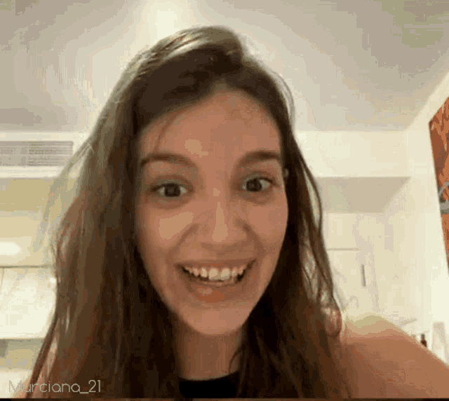 a woman with braces on her teeth is smiling in front of a screen that says murciano_21 on it