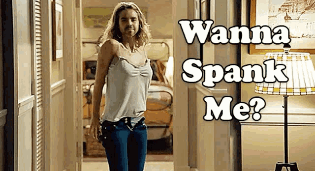 a woman walking down a hallway with the words " wanna spank me " written on it