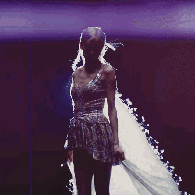 a woman in a dress with a white cape