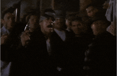 a man in a white shirt is standing in the dark