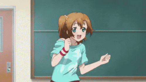 a girl in a blue shirt is standing in front of a blackboard .