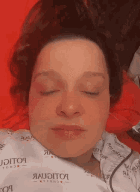 a woman is laying in a hospital bed with her eyes closed